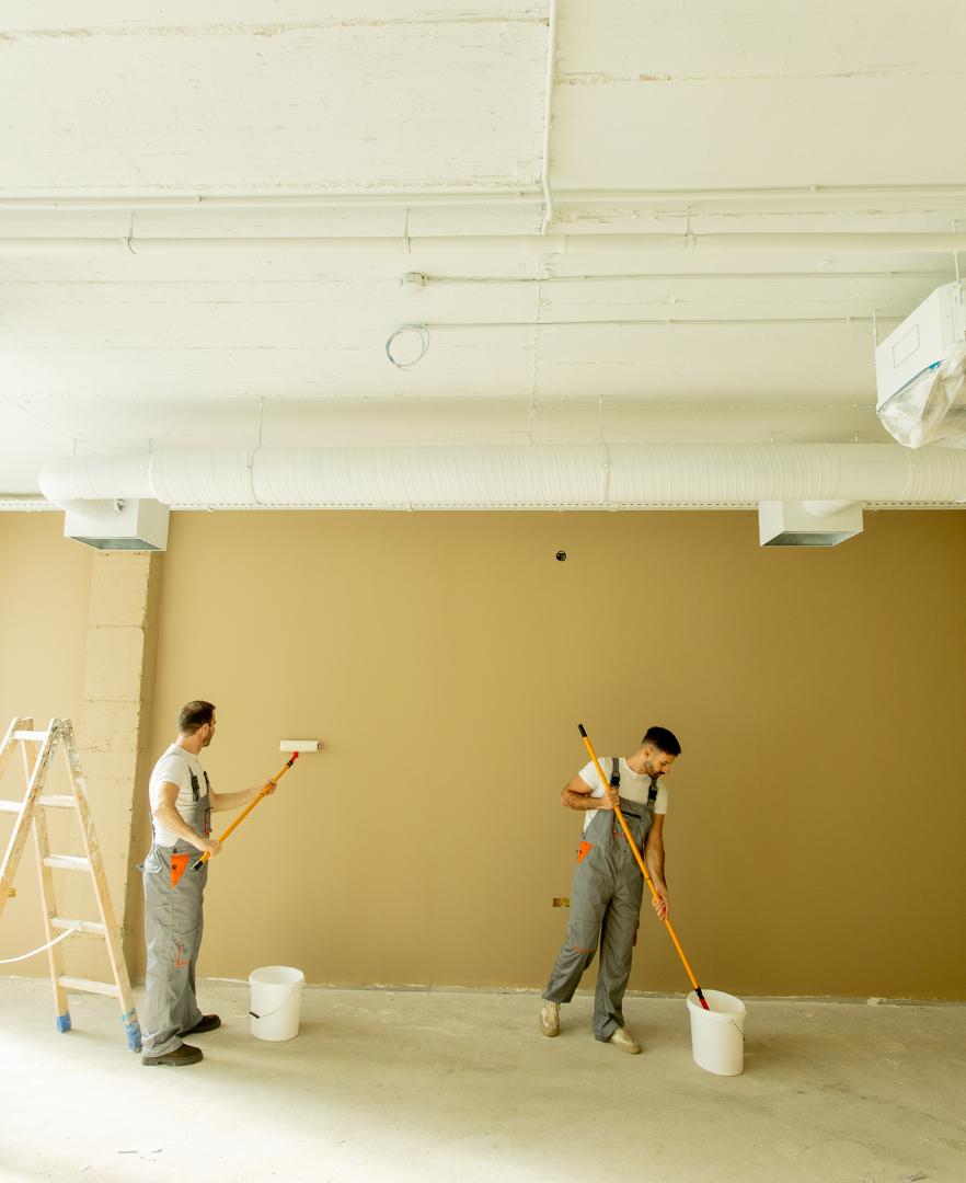 Professional painters completing a commercial painting project inside a modern office space in Calgary.