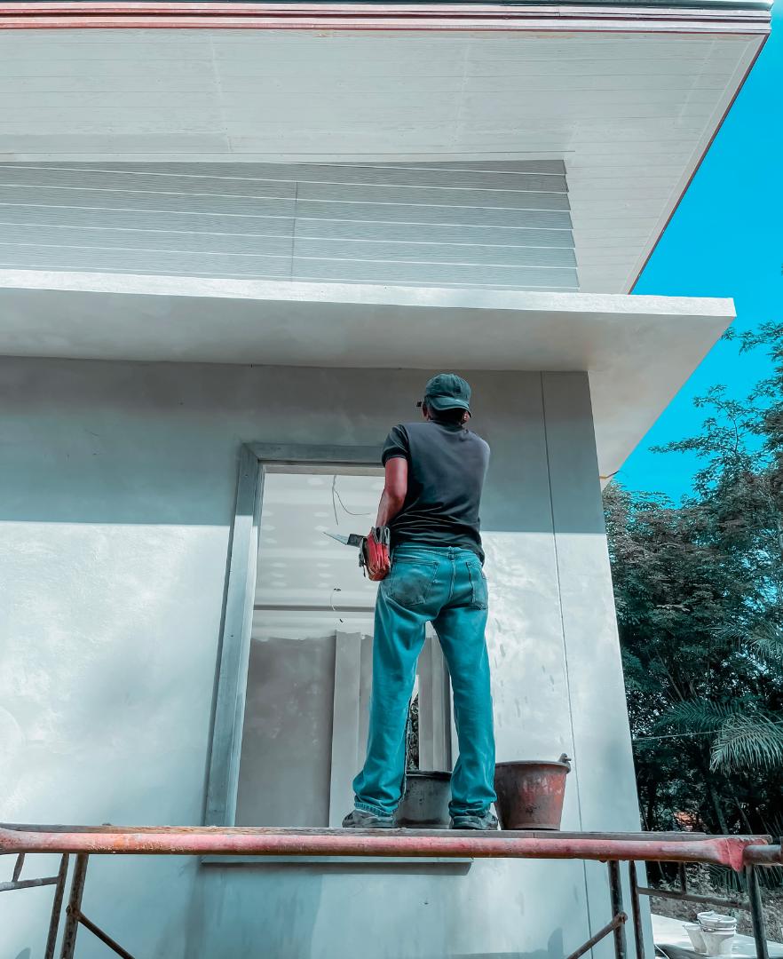 Professional painters refreshing the exterior of a residential home with premium exterior paint suitable for Calgary's climate.