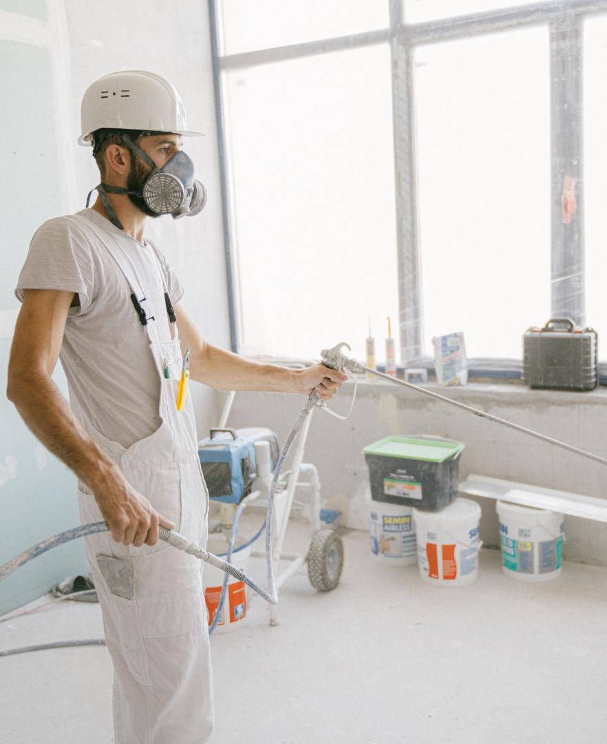 Professional painter wearing protective painting gear, showcasing skilled workmanship and attention to detail.